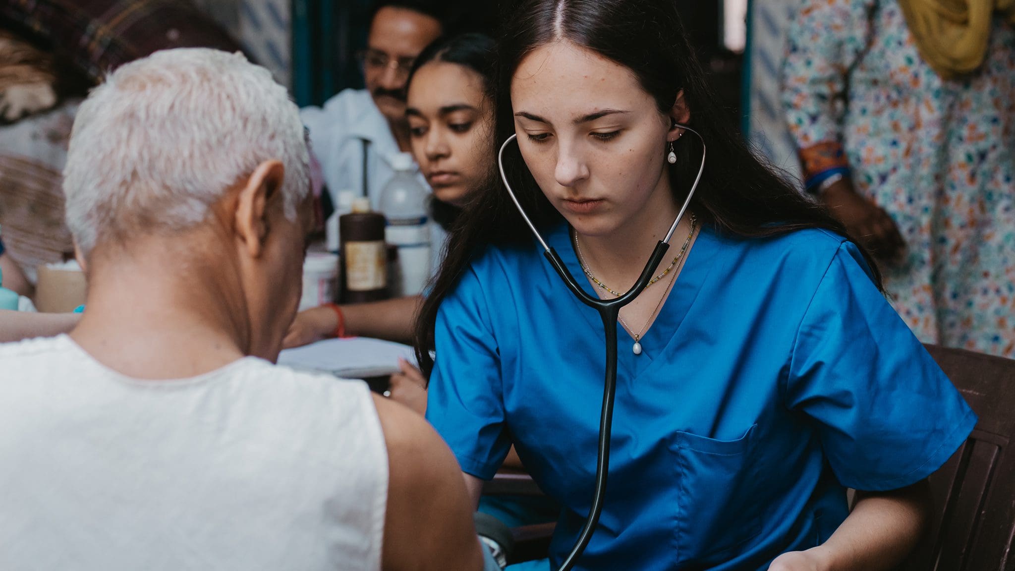 Community health worker providing medical care during outreach event in India.
