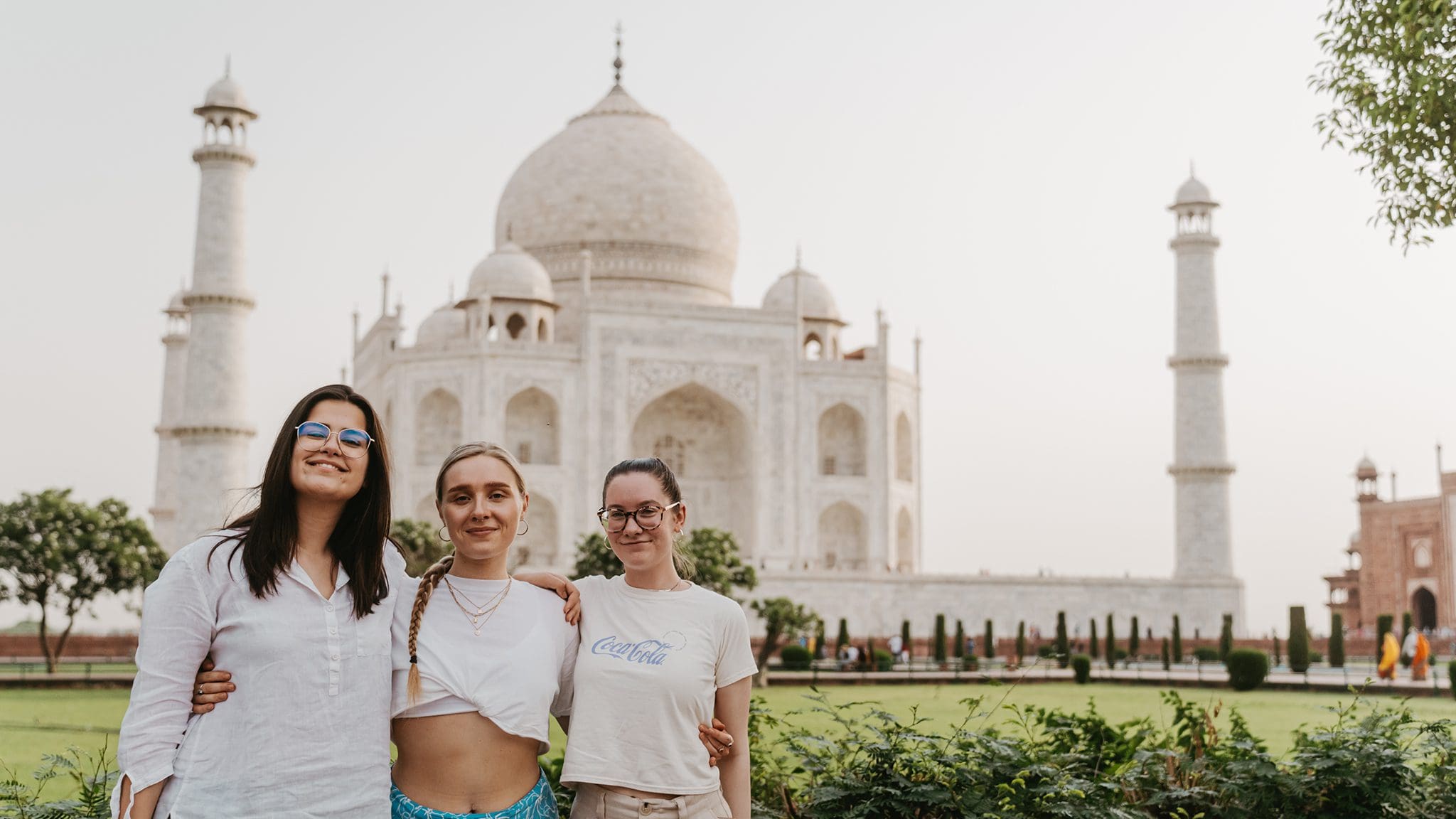 Friends enjoying a selfie in front of the Taj Mahal in India.